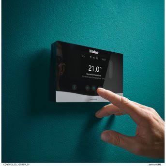Vaillant sensoHOME smart thermostat mounted on a deep teal wall